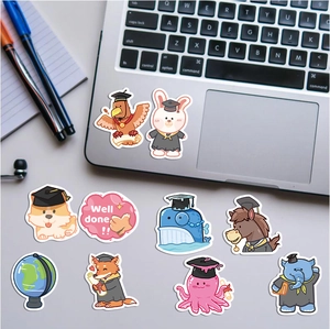 Close-up of animal graduation stickers with Well Done text on a laptop surface