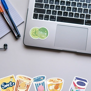 Close-up of cute cartoon snack stickers applied to a laptop and office desk setup