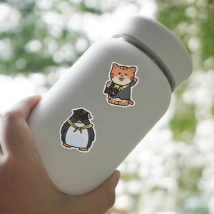 Waterproof cartoon cat and penguin graduation stickers applied on a white matte bottle