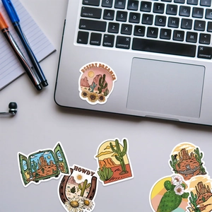 Waterproof desert themed stickers with cactus and sunset designs on a laptop