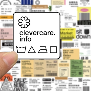 Detail shot of white square clothing care labels with laundry symbols and black icons
