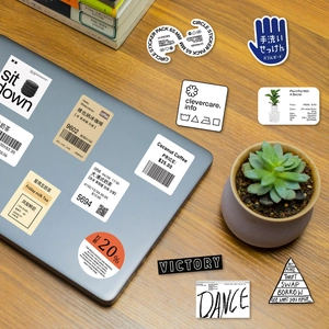 Close-up of decorative coffee and milk tea cup stickers on a laptop and wooden surface