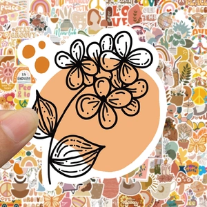 Close-up of a hand holding a floral BOHO sticker with warm earth tones and PVC waterproof texture