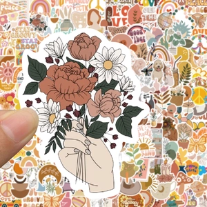 Close-up of a hand holding a vintage BOHO sticker featuring a colorful floral bouquet