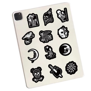 Detailed macro view of black gothic skull stickers on a tablet back with Never Better text