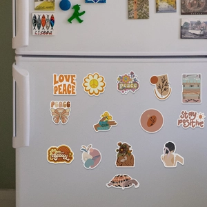 Close-up of boho stickers on white surface featuring vintage flowers and peace signs