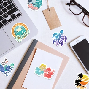 Detail of Hawaii vinyl stickers featuring Aloha and tropical motifs on a laptop and notebook