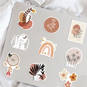 Detail of BOHO art stickers with rainbows and botanical motifs on laptop surface