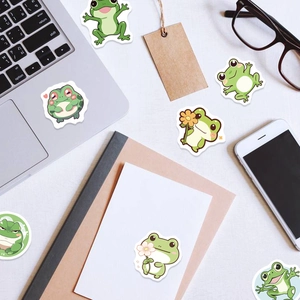 Set of 100 cute frog reward stickers for kids shown on a laptop and desk setup