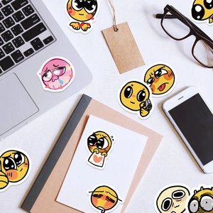Detail view of cute yellow emoji stickers on a laptop and notebook in a home office scene