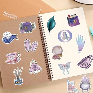Purple mystical wizard stickers featuring moons and cauldrons on a brown notebook