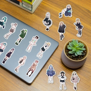 Détail de stickers filles anime mignons sur un bureau et un ordinateur portable