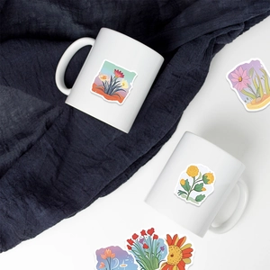 Minimalist white ceramic mug set with floral plant illustrations on dark blue fabric