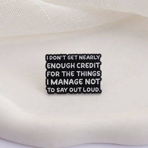 Minimalist black enamel brooch with creative English slogan on white knit background