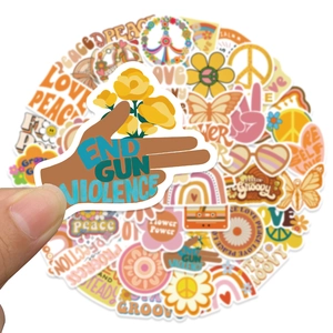 Close-up of hand holding a vintage boho aesthetic sticker with warm retro 70s patterns