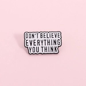 Creative enamel pin with Don't Believe Everything You Think quote on pink background