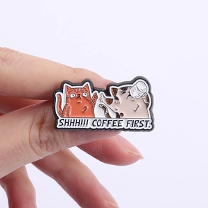 Detailed close-up of cartoon enamel cat pins with Shhh Coffee First lettering