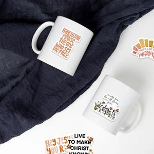 Close-up of waterproof BOHO religious vinyl stickers applied to a white ceramic mug