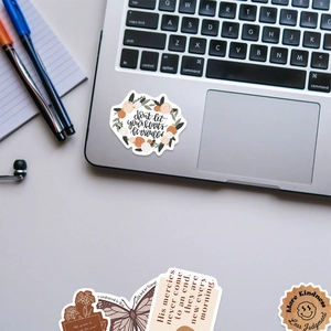 Detail of BOHO art stickers featuring floral and butterfly designs on a laptop and notebook