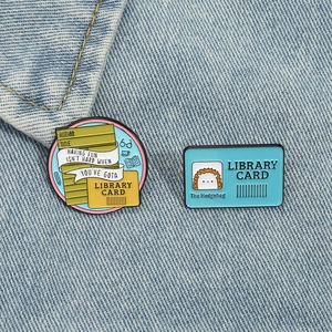Library card enamel pin set with cute hedgehog and glasses on blue denim fabric