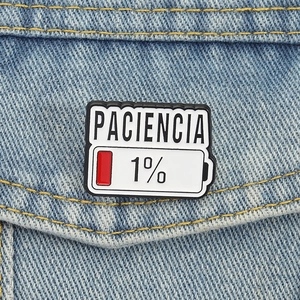 Creative Paciencia low battery enamel pin badge pinned on blue denim fabric background