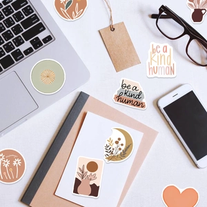 Flat lay of Boho art stickers on laptop and notebook with earthy tone plant patterns