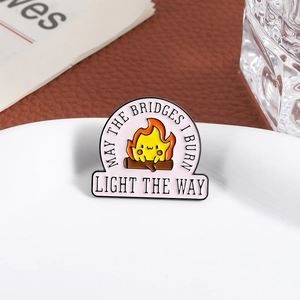 Broche en émail créative d'un mignon démon de feu assis sur une bûche en bois