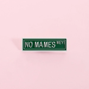Creative green rectangular metal enamel pin with NO MAMES WEY engraving on pink background