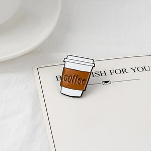 Detail of coffee cup enamel pin with embossed text on a white greeting card accessory