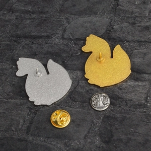 Detail view of gold and silver alloy fox brooch backs with secure butterfly clutches