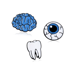 Dettaglio di spillette in smalto con design di cervello blu, bulbo oculare e dente bianco