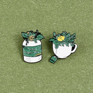 Détail macro de pin's en émail avec flacon de médicament et tasse avec plantes vertes