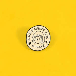 Detail view of Always Sleepy Club Member enamel pin on vibrant yellow background