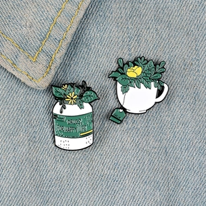 Plant pins in cup and medicine jar set on denim background for clothes accessory