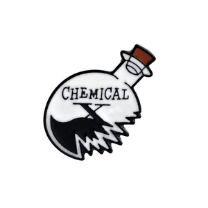 Detailansicht einer Emaille-Brosche in Form eines Bechers mit Chemical X Text