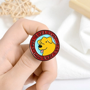 Detail of a round metal Cool Dogs Club enamel pin with a cute yellow puppy motif
