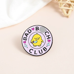 Detail of round purple enamel pin featuring a cartoon duck and Bad Bitch Club text