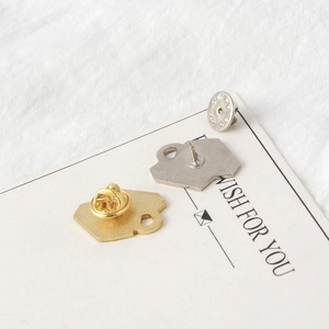 Detail view of gold and silver metal brooch backs with butterfly clasps on card