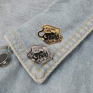 Punk black cat in box enamel pins with IF IT FITS I SITS slogan on denim jacket
