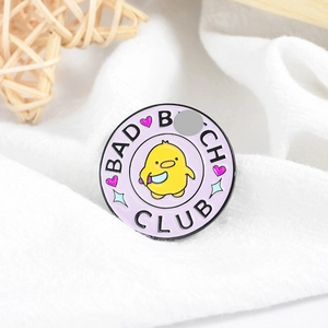 Macro shot of cartoon enamel badge featuring a chick with knife and Bad Bitch Club slogan