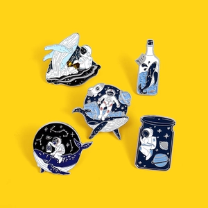 Détail du lot de 5 broches en émail avec motifs d'astronaute, de baleine et de galaxie