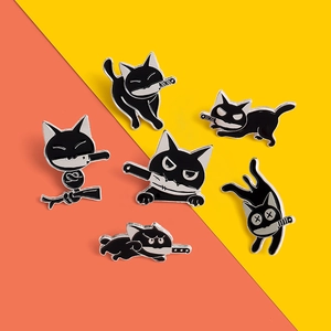 Close-up of cute black cat enamel pins with knives on yellow and orange background