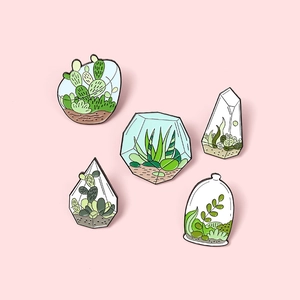 Detailed view of 5-piece enamel pins featuring terrarium plants and succulent designs