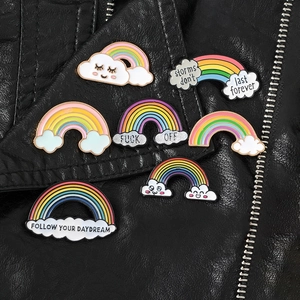Detail of colorful enamel rainbow pins with motivational quotes on black leather jacket