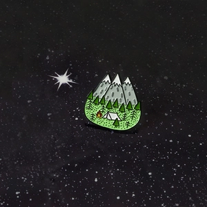 Broche créative en émail avec montagnes enneigées, pins et motif de feu de camp