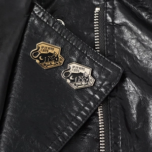 Detail of black cat enamel pins on leather jacket lapel with funny letter engraving