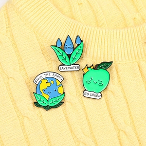Detail of Save the Earth enamel pins featuring earth, water drop, and green apple designs