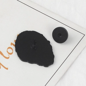 Detail of the black enamel pin back with metal pin and secure rubber clutch backing