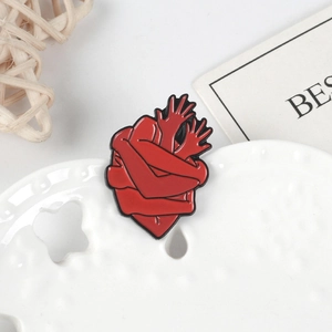 Broche créative en émail avec des mains entourant un cœur rouge vif en alliage
