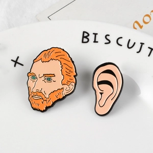 Detailed macro of cartoon Van Gogh enamel pins with ear component on a white plate